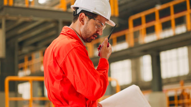 istock Electric train engineer mechanic staff worker with design plan for maintenance schedule check train running service in train factory workshop 2113825695