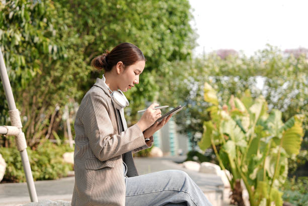 istock Woman using digital tablet outdoors 2113849750