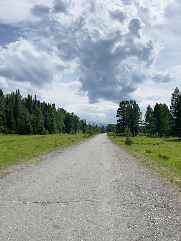 A country road in a mountainous area in changeable weather. Road trips.