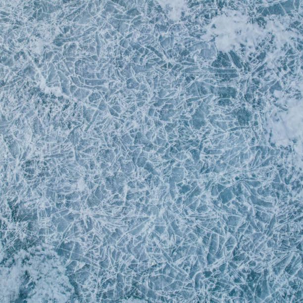 istock Cracked ice on a frozen lake, view from the top. Mouse background. 2113866736
