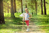 Cute little girl walking and catching butterflies with her scoop-net on sunny summer day