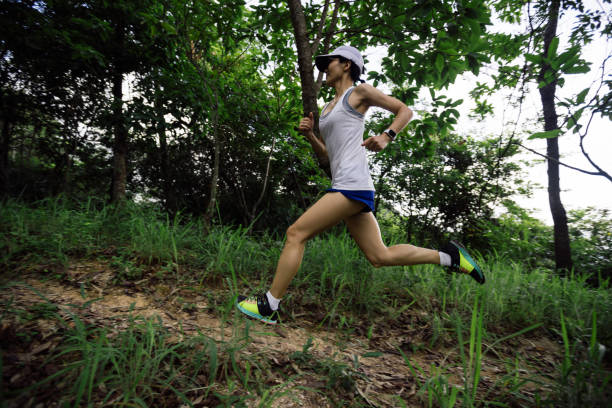 istock Woman runner running on forest trail 2113876420
