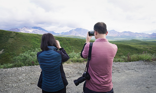 Tourists taking photos of mountains Denali National Park and Preserve. Alaska. USA.