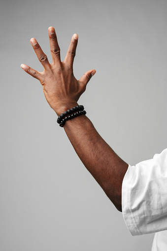 African Man Arm Raised in the Air on gray background