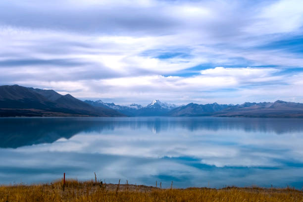 Stunning gray clouds are reflected in the lake Pukaki