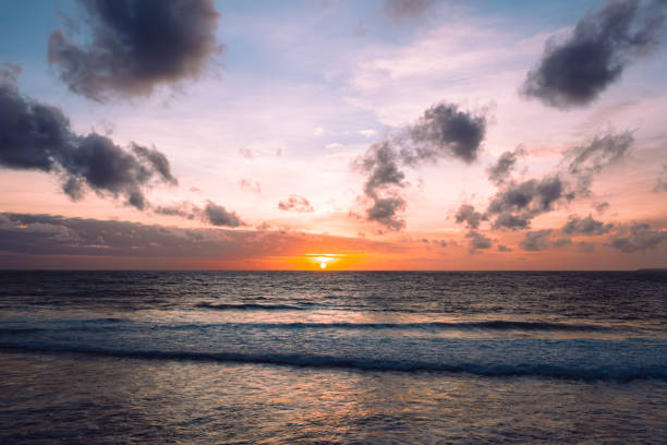 Sumba Island Indonesia Romantic Colorful Sunset. Vibrant sunset sky over the Sumba Island Seascape at the natural Sumba Nihisumba Beach. Indian Ocean Waves splashing towards the natural beach under colorful sunset twilight cloudscape. Lifted Drone View. Nihisumba Beach, Sumba Island, Nusa Tenggara Timur, Indonesia, Southeast Asia