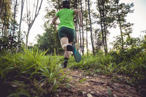 istock Woman trail runner running at tropical forest mountain peak 2113952316