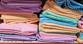Colorful terry towels are on the shelf of the store.