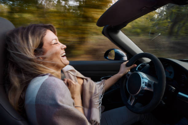 istock Young cheerful woman enjoying while driving a convertible car. 2113978114