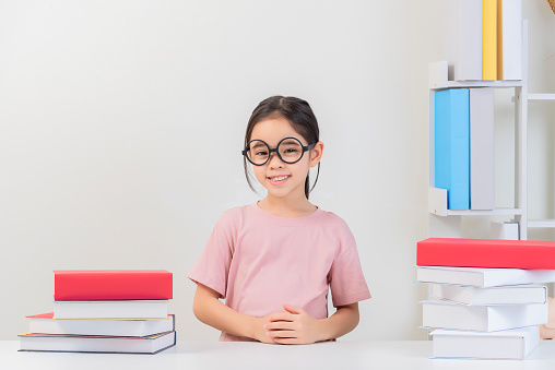 white background, a girl asian cute reads books, a book lover, a student on the teble among a large number of books