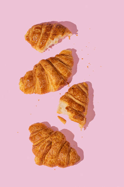istock Flat lay of  fresh croissants on pink  background with shadow. 2114008331