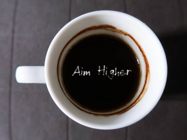 istock Coffee in a cup with text AIM HIGHER ,concept of decision making to work harder, try new things, chase dreams through thick and thin until getting to the top. 2114035605