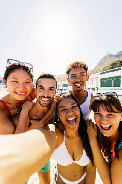 istock Diverse group of people having fun enjoying summer vacation in the beach 2114042380