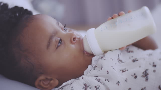 Baby drinking milk from milk bottle
