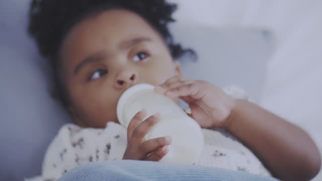 Baby drinking milk from milk bottle