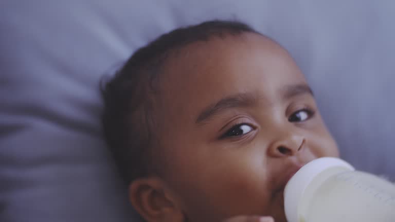 Cheerful baby sleeping and drinking milk