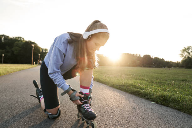 Woman preparing to rollerblade in the park