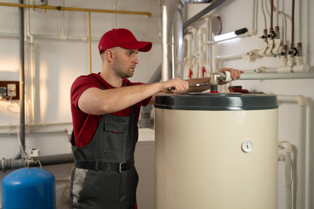 Man in Red Shirt Fixes Water Heater stock photo
