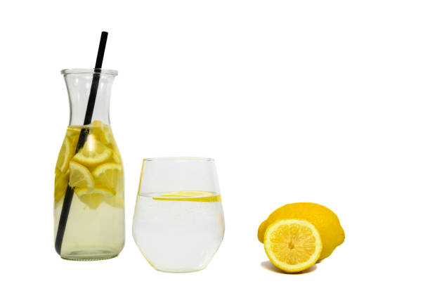 water with lemon in a glass, refreshing lemon drink isolated on white background - lemon fruit portion citrus fruit imagens e fotografias de stock