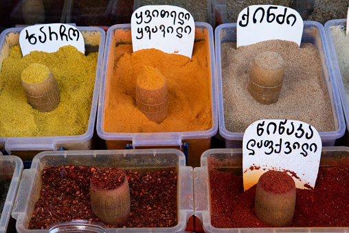 Colorful, freshly ground spice powders, including hot pepper, cumin, turmeric, ginger and pepper, at an outdoor food market in Tbilisi, Georgia.