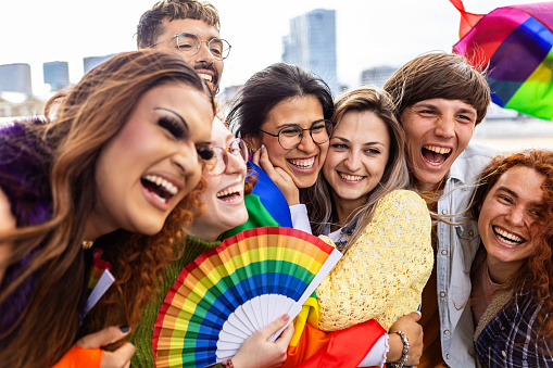 Young diverse people celebrating gay pride festival outdoors. LGBTQ community concept.