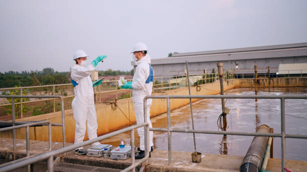 istock Two specialists taking water samples at a sewage treatment plant. 2114186719
