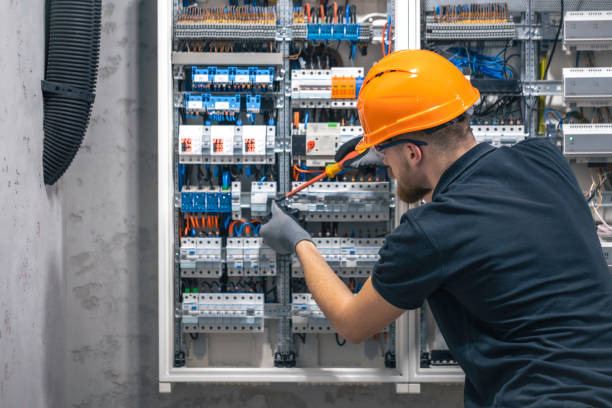istock A male electrician works in a switchboard with an electrical connecting cable. 2114200575