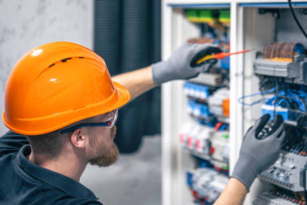 istock Male electrician working in a switchboard with fuses. 2114200585
