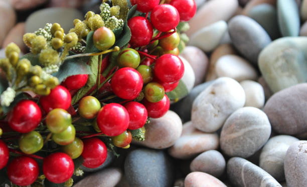 Decorative Wreath With Artificial Berries And Branches On Pebbles