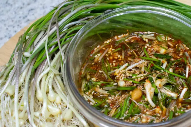 Dalrae seasoning sauce and fresh Wild Chive vegetables Close-up. Dalrae seasoning sauce made with wild chives as the main ingredient, which Koreans enjoy eating in spring.