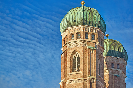 Munich, Germany - December 27, 2023: Towers of the Frauenkirche in Munich against a blue sky.