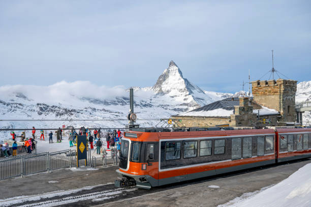 Gornergrat Train arrives at station below Matterhorn mountain in winter