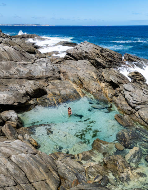istock a woman is bathing in a small pool on the beach 2114276091