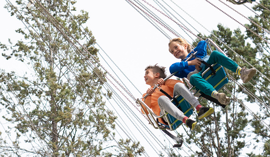 Children riding a flying swing attraction at an amusement park