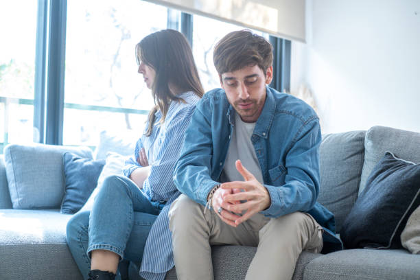 istock Engaged couple with relationship problems sitting on the sofa with their backs to each other after an argument, conflicts in marriage, upset couple after a dispute, making decision to break up and divorce 2114289231