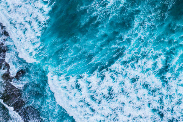istock Turquoise Waves Crashing on Rocky Shoreline, Bali. 2114313245