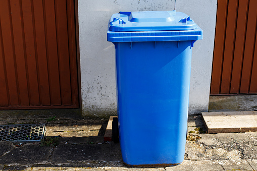 Container for paper and cardboard. waste sorting. blue waste sorting container in the backyard