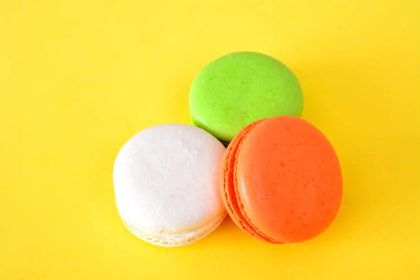istock colorful macarons isolated on yellow background close up 2114318969