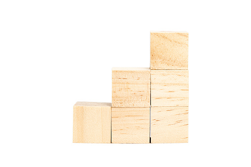 Stacked wooden cubes forming an ascending staircase to the right isolated on a white background.