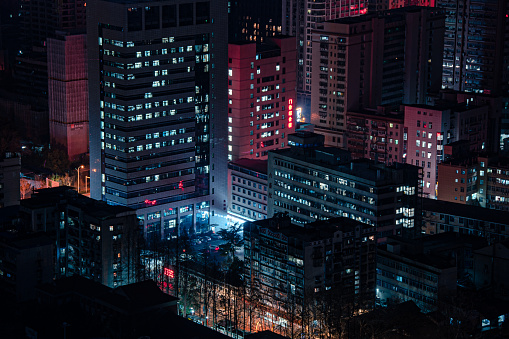 Wuhan, China – February 17, 2024: An aerial view of vibrant night-time cityscape featuring illuminated skyscrapers in Wuhan