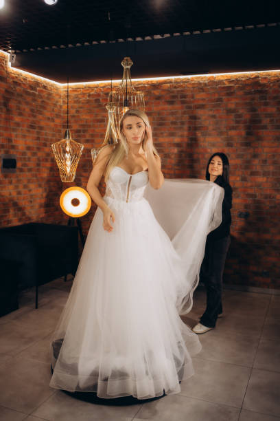 istock beautiful bride trying on a wedding dress 2114339949