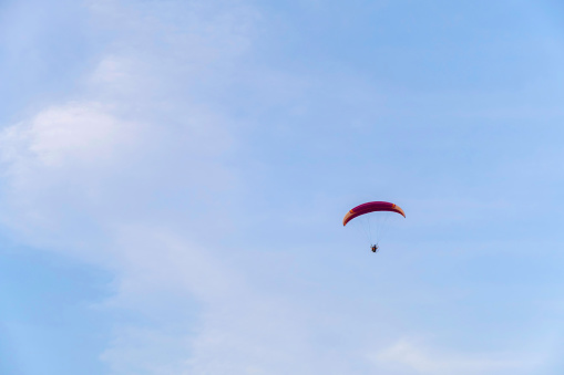 paramotor glider flying in the air deep blue paraglider on blue bright sky