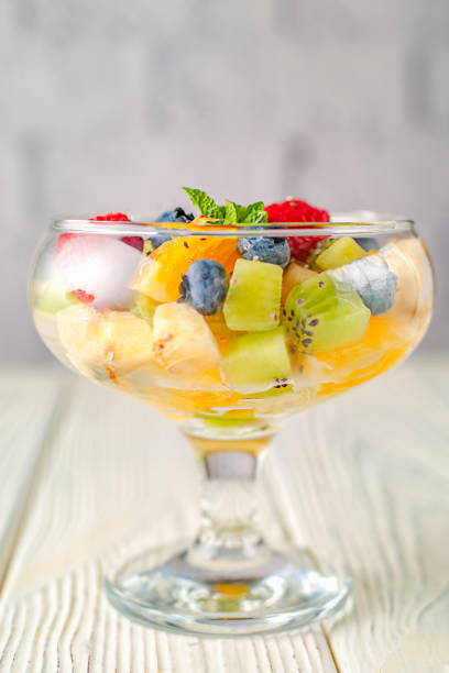 Delicious dietary fresh fruit salad on a background of a light brick wall