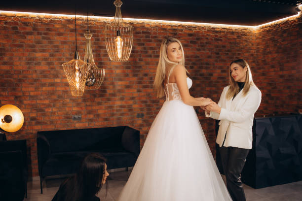 istock Attractive bride choosing a wedding dress in the store 2114341572