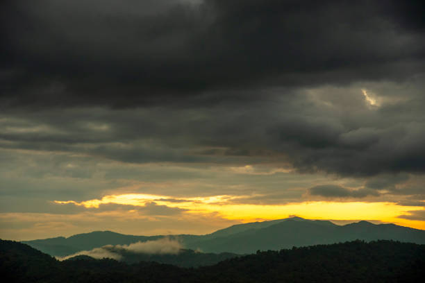 Scenic view dramatic beautiful sunset sky. Natural Sunset Sunrise on meadow silhouette shadow dark land. Vibrant dramatic sky on sunset, dawn, sunrise in Countryside. Landscape Colorful Sky At Sunset