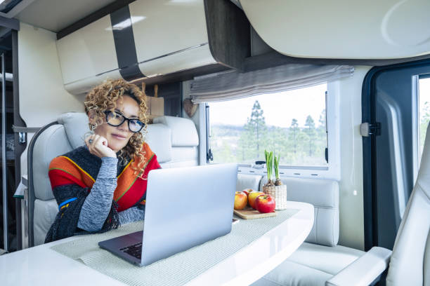 istock Online remote worker using laptop inside a modern camper van living vanlife and wanderlust adventure travel lifestyle. Digital nomad concept. Living off grid people. Nature view outside the window 2114360854