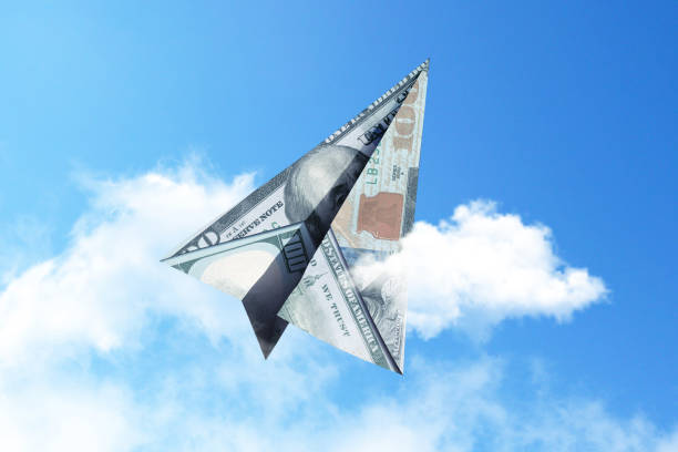 istock Paper airplane 100 dollars flies into the sky with clouds, creative idea. Startup and investment finance, concept. Insurance and deposits 2114369298