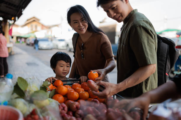 istock Family browsing a local market together 2114371341