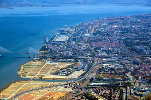 Lisbon, Portugal: aerial view of the Mar da Palha (Sea of Straw) inland sea in the Tagus River estuary, the eastern area of Lisbon and the Montijo / Alcochete on the southern bank, connected by the Vasco da Gama bridge. At the bottom the River Trancão can be seen, meandering towards its mouth, separating Bobadela from Sacavém. Above the bridge lie the Expo, Moscavide and Olivais areas. On the horizon is the south bank (Barreiro and Seixal areas).