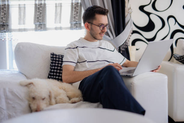 istock Young man relaxing at home and using laptop to browse the internet 2114391074